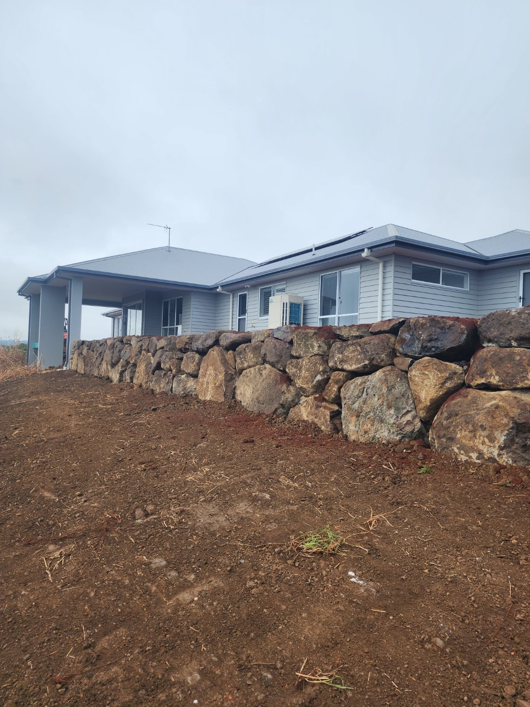 Rock retaining wall beside a residential home